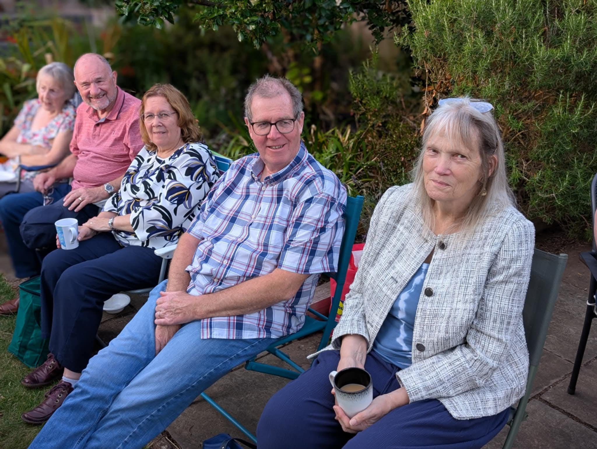 Bill and Andy look happy while their wives drink coffee